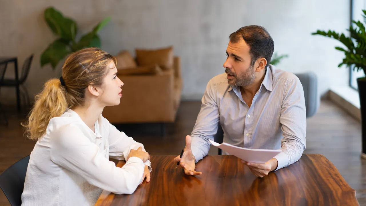 Consultor mostrando um documento a uma empresária em uma reunião de trabalho